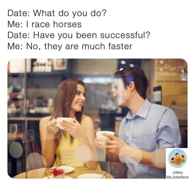 A woman and a man are sitting at a table in a cafe, smiling and holding coffee cups, engaging in a c.