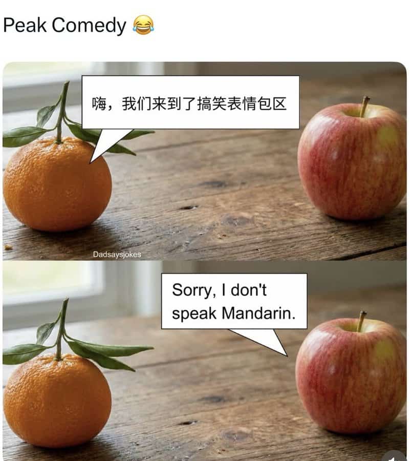 Bright orange and red apple with speech bubbles, humorous exchange about language barrier, on wooden.