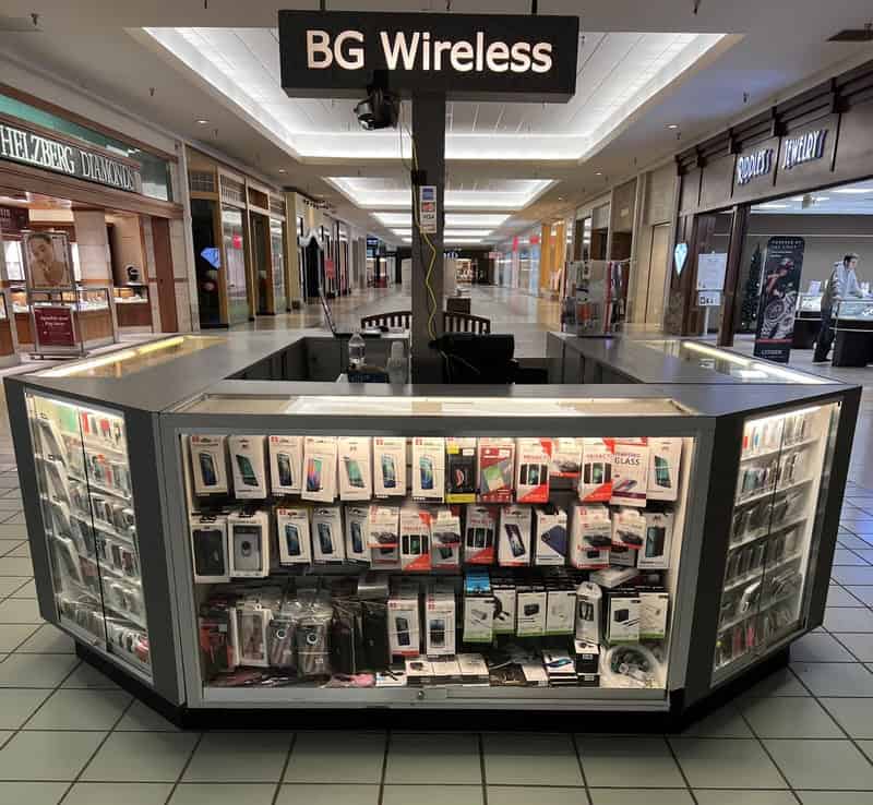 Empty kiosk selling mobile accessories in a mall corridor.