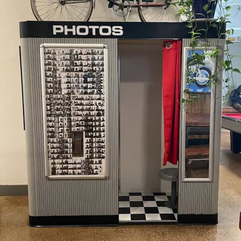 Photo booth with black and white photos and red curtain at the mall.