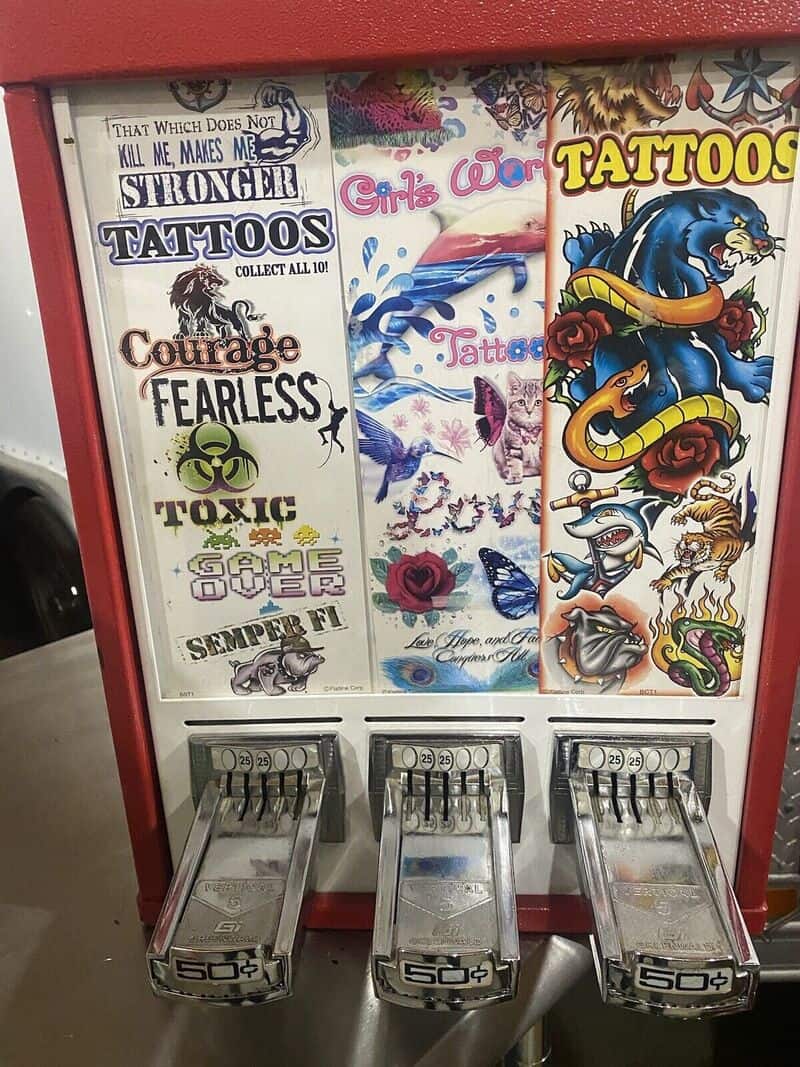 Tattoo design posters and tattoo machine at mall kiosk in the 90s or 2000s.