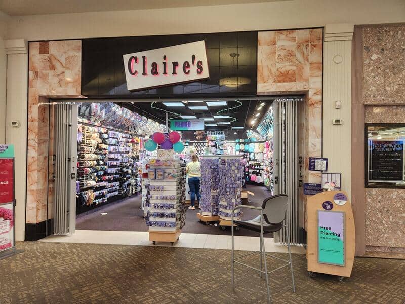 Claire's store entrance with colorful accessories and balloons inside.