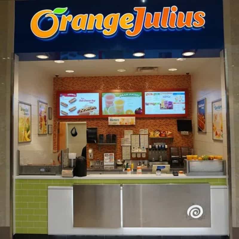Orange Julius stand with menu screens and colorful decor.