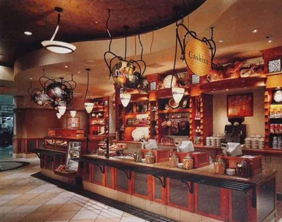 Retro-style diner counter with hanging signs for cashier and desserts.