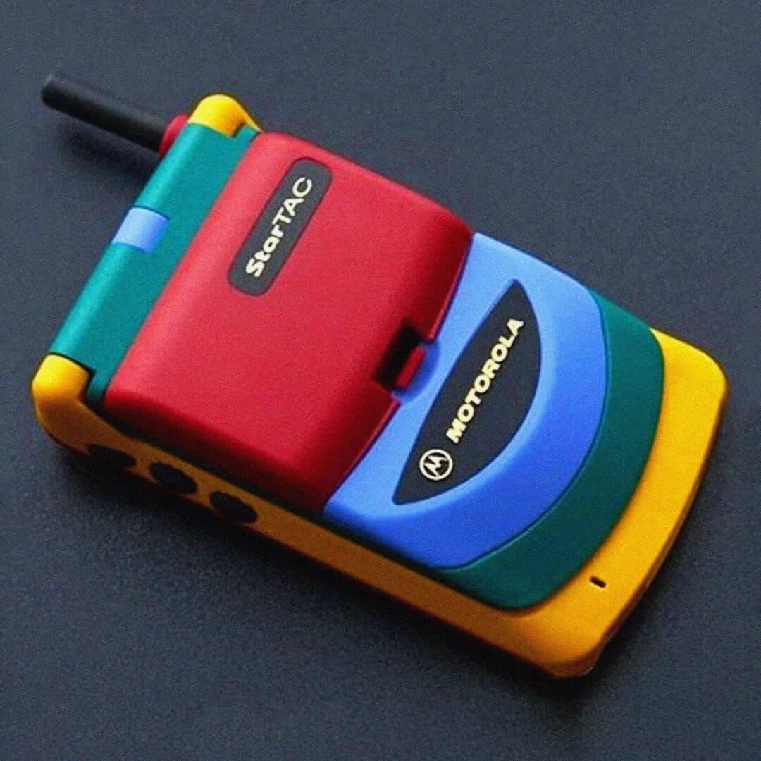 Colorful 90s-style Motorola flip phone with stickers and bright colors.