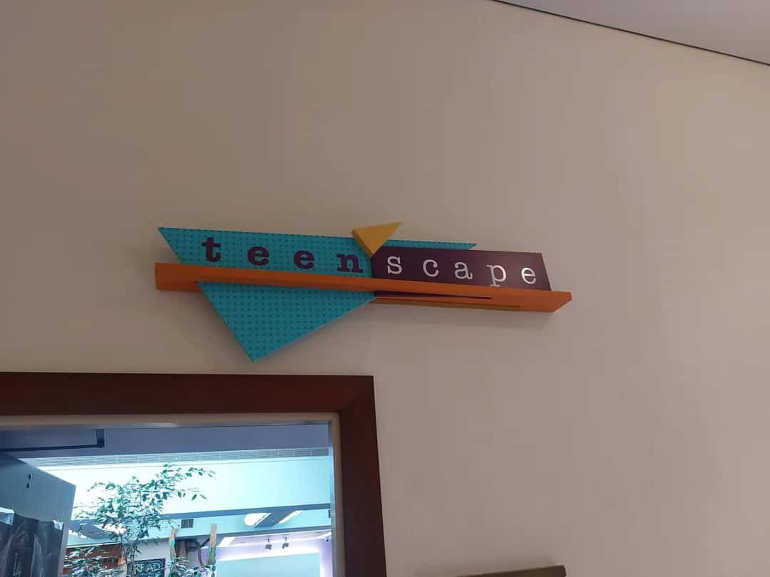 Teenscape sign with colorful geometric shapes and text on a wall.