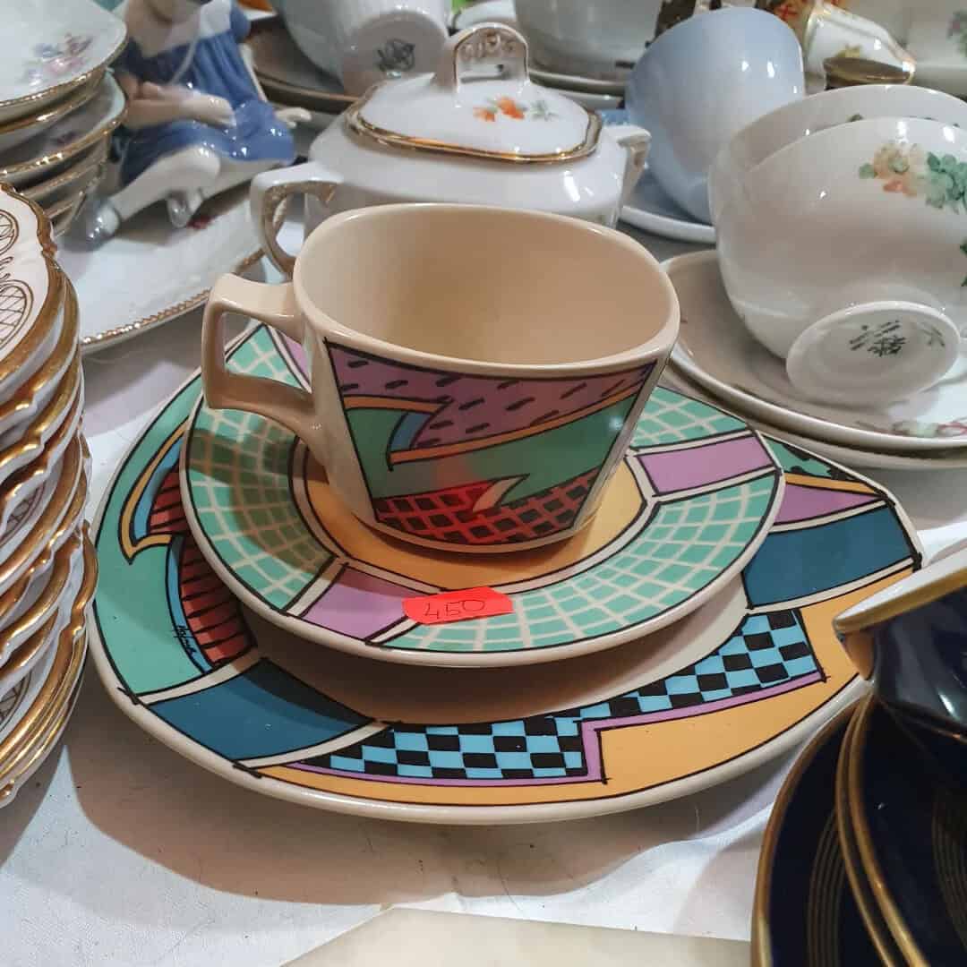 Colorful 90s-style ceramic cup and saucer set with geometric patterns.