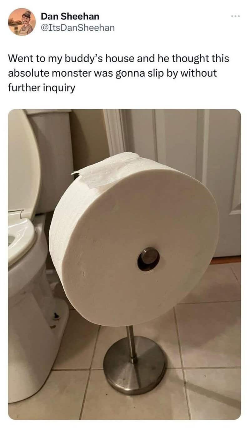 Large roll of toilet paper on a stand in a bathroom.