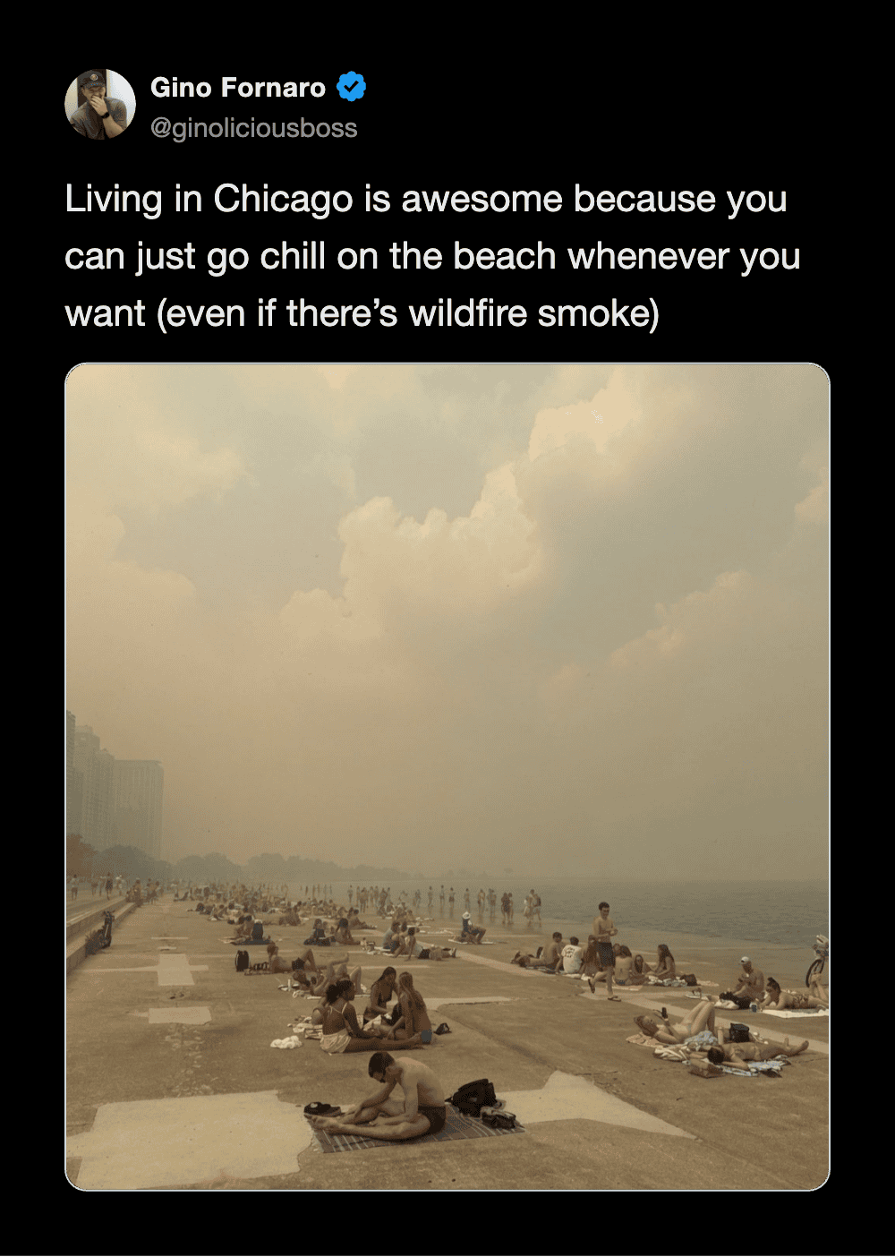 People relaxing on the beach in Chicago with smoky sky from wildfire smoke.