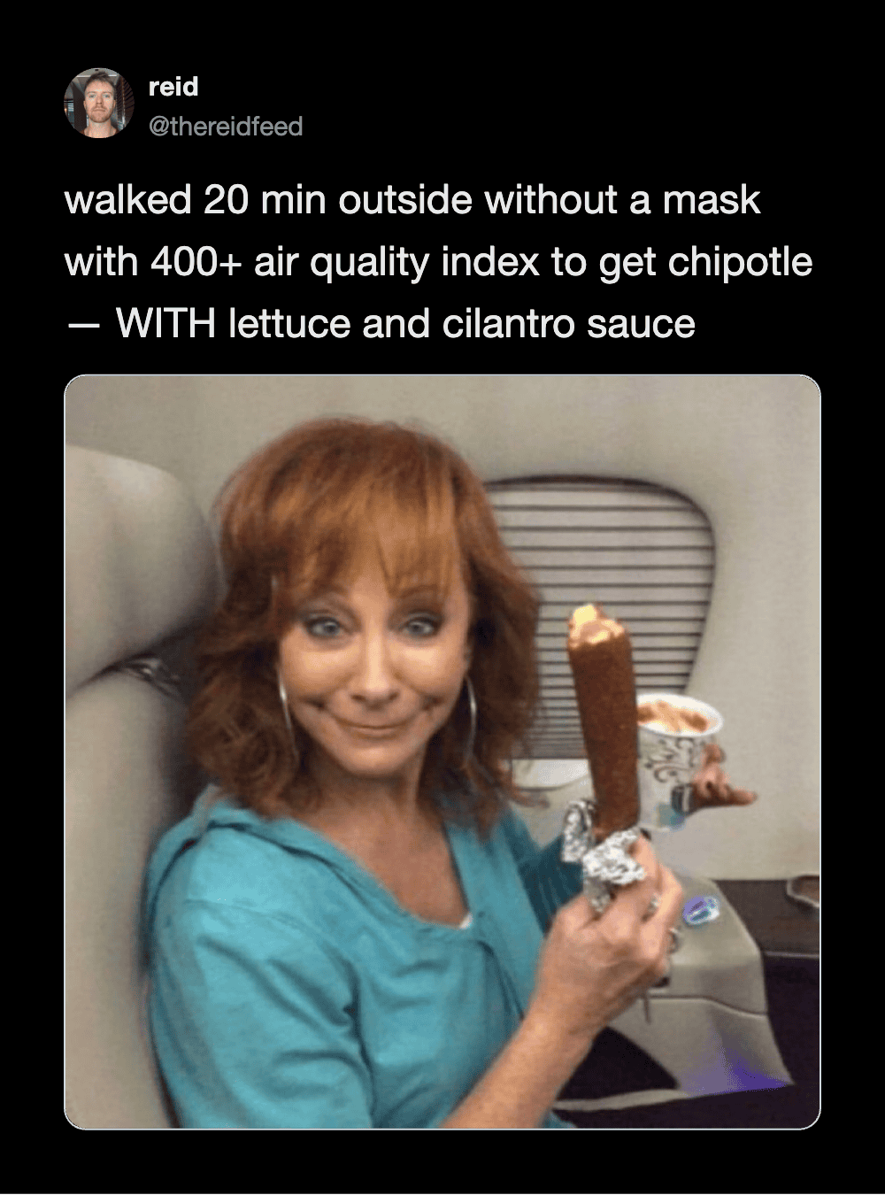 Woman with red hair holding a chipotle burrito outside on a plane.
