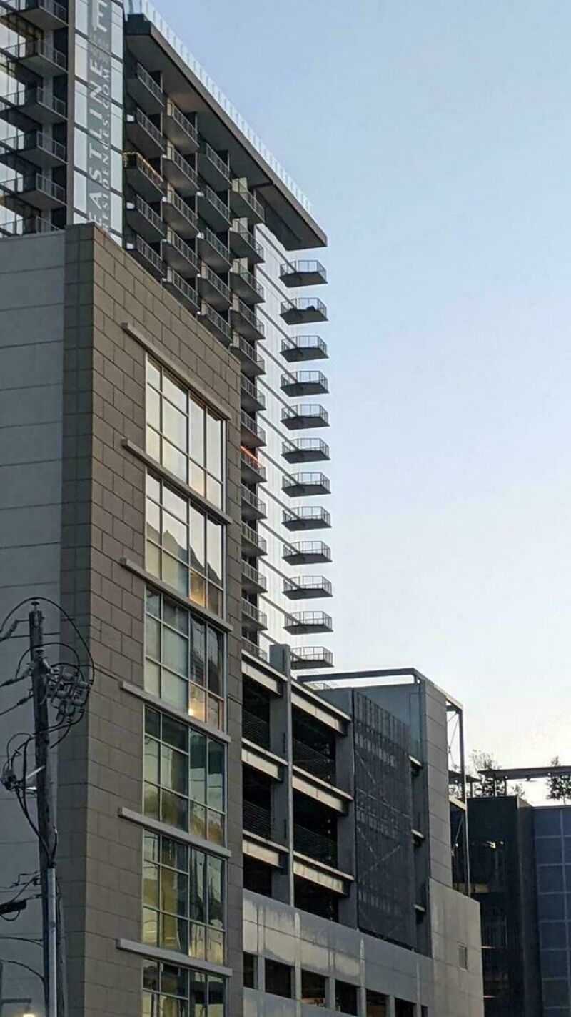 Tall modern building with a series of balconies extending outward in a line.