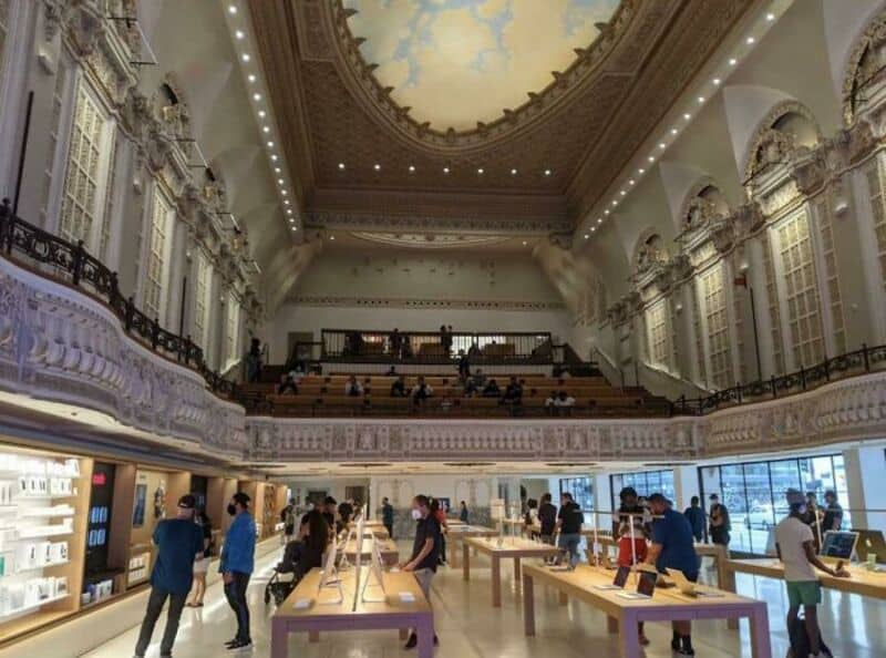 Interior of a modern Apple Store with high ceilings and ornate architecture.