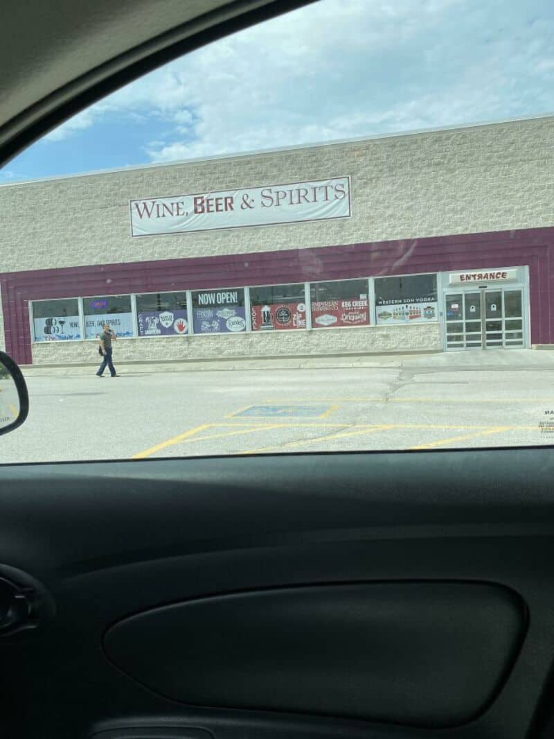 Store sign reads 'WINE, BEER & SPIRITS' outside a retail shop.