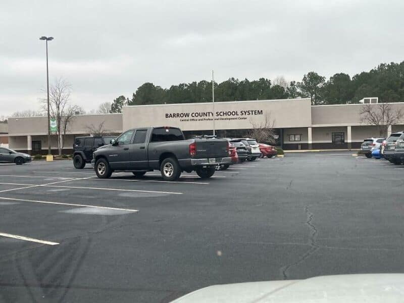 Parking lot in front of Barrow County School System building on a cloudy day.