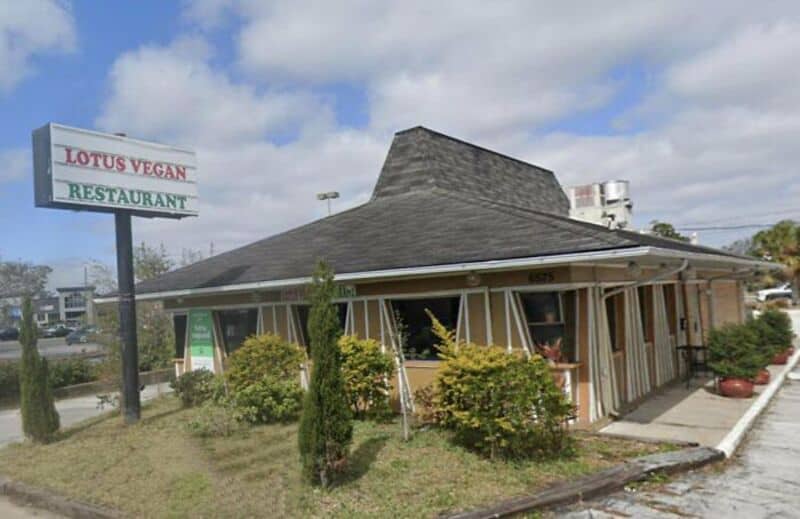 Converted building with a sloped roof and large windows, labeled Lotus Vegan Restaurant.