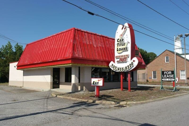 Empty fast food restaurant with a red roof and a large sign for car title loans.
