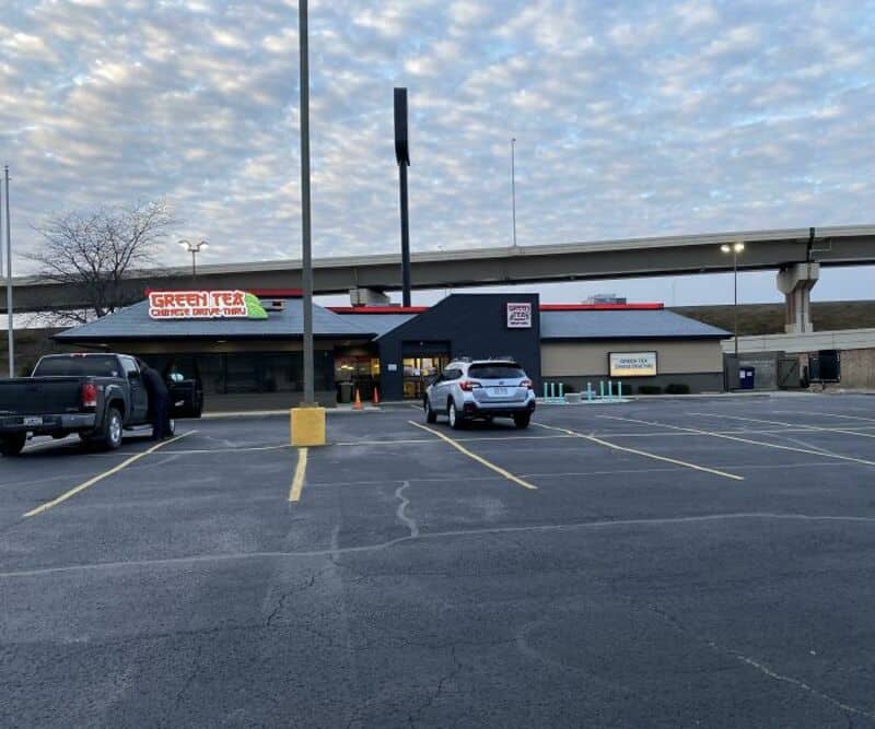 Empty parking lot in front of Green Tex restaurant with a highway overpass above.