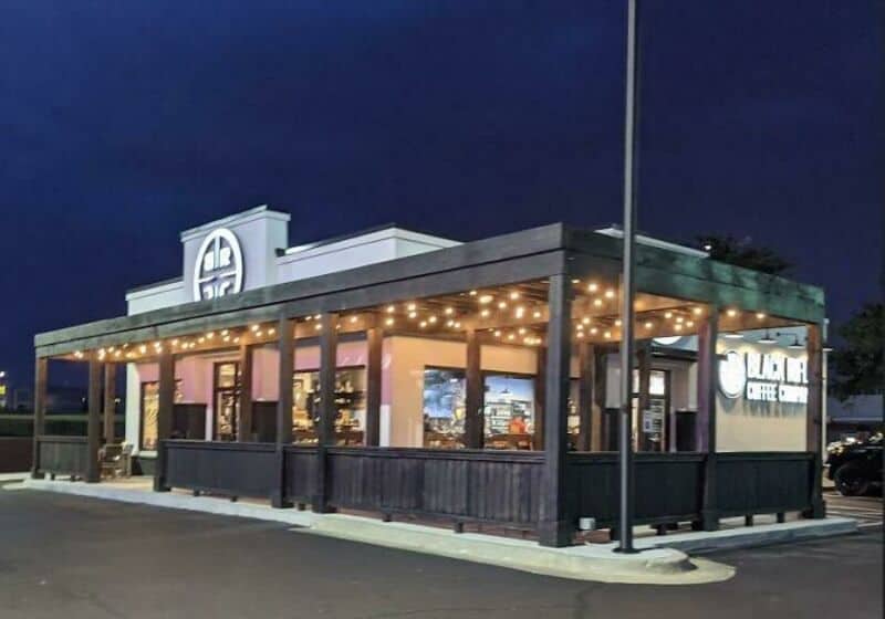 Converted building with string lights, dark exterior, and a sign reading 'CALI' at night.