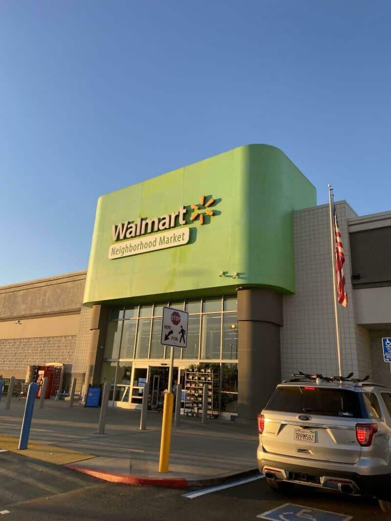 Walmart Neighborhood Market store with green facade and parking lot.