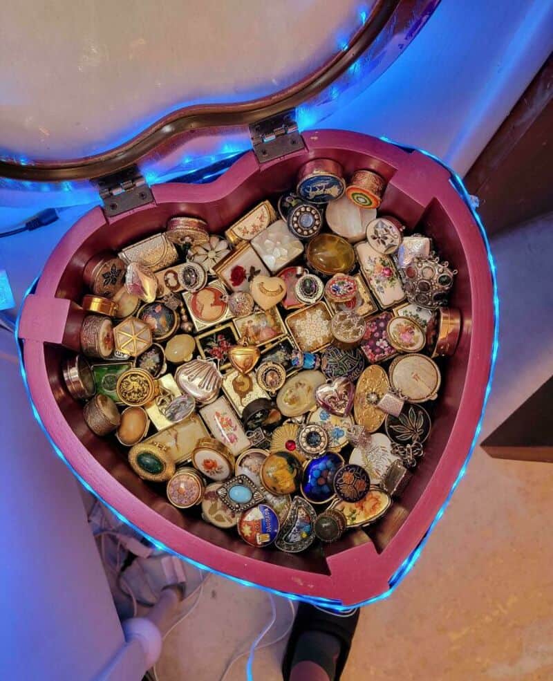 Heart-shaped box filled with various rings and jewelry pieces.