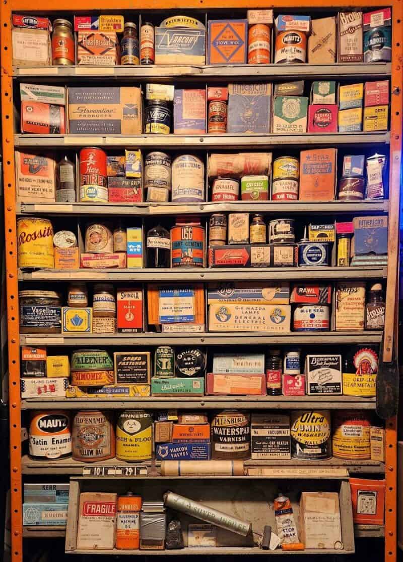 Shelf filled with various cans and boxes of paint, varnish, and related products.