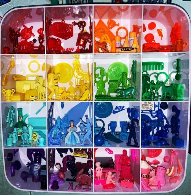 Colorful plastic toys organized by color in a compartmentalized box.