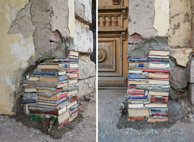 Books stacked in a makeshift repair in a damaged wall corner.