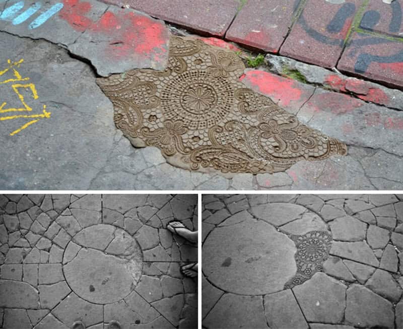 Intricate lace-like pattern on cracked pavement with graffiti and bricks nearby.