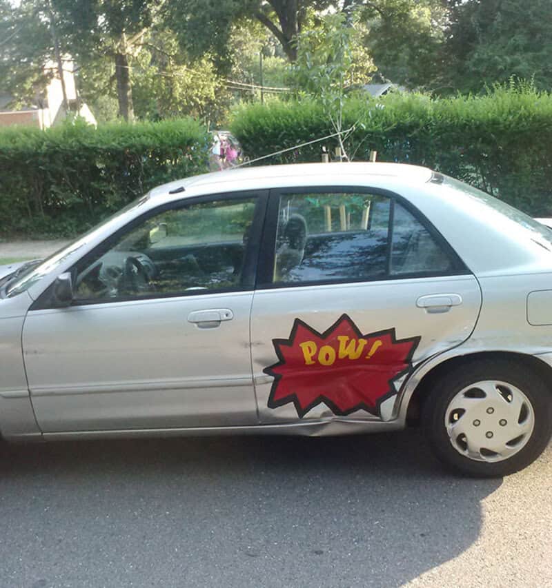 Silver car with a comic-style 'POW!' sticker on the side door.