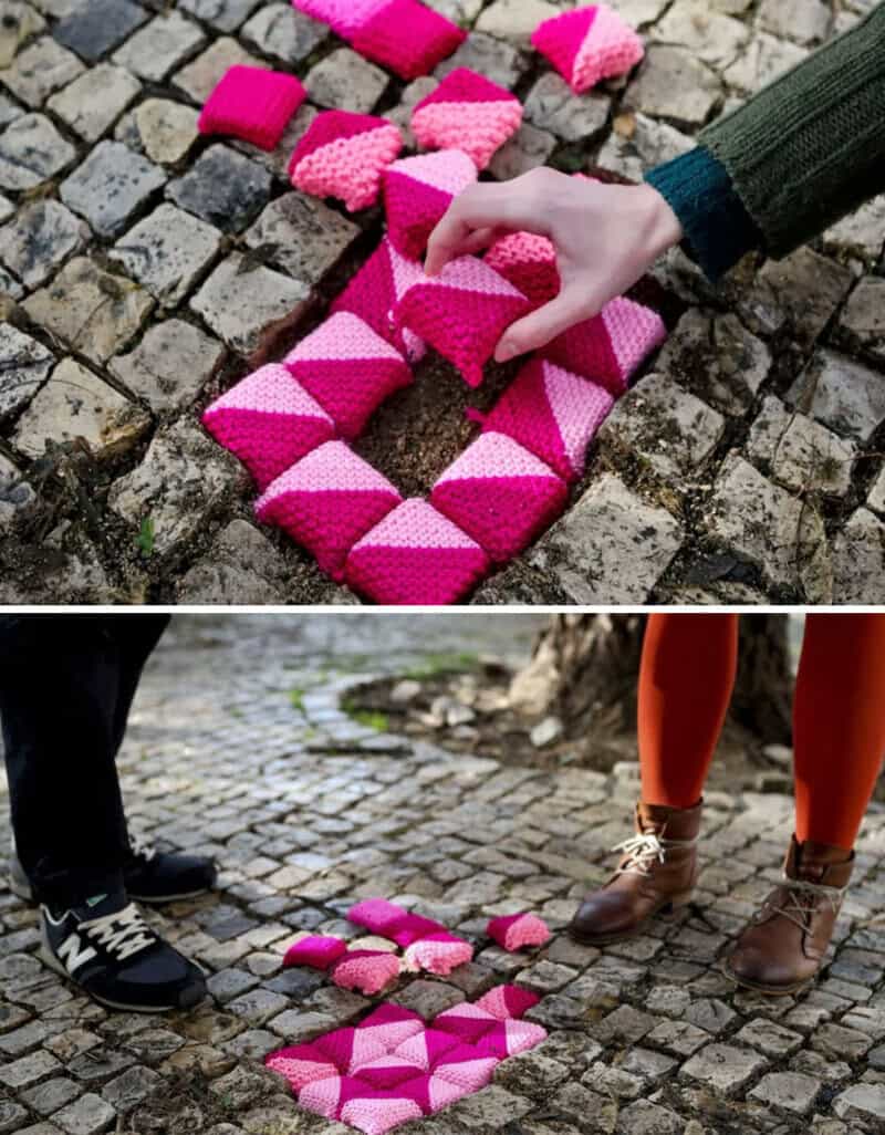 People repairing a cobblestone street with pink and white foam blocks.