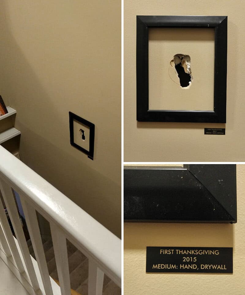 Framed hole in wall with a plaque below reading 'First Thanksgiving 2015, Medium: Hand, Drywall'.