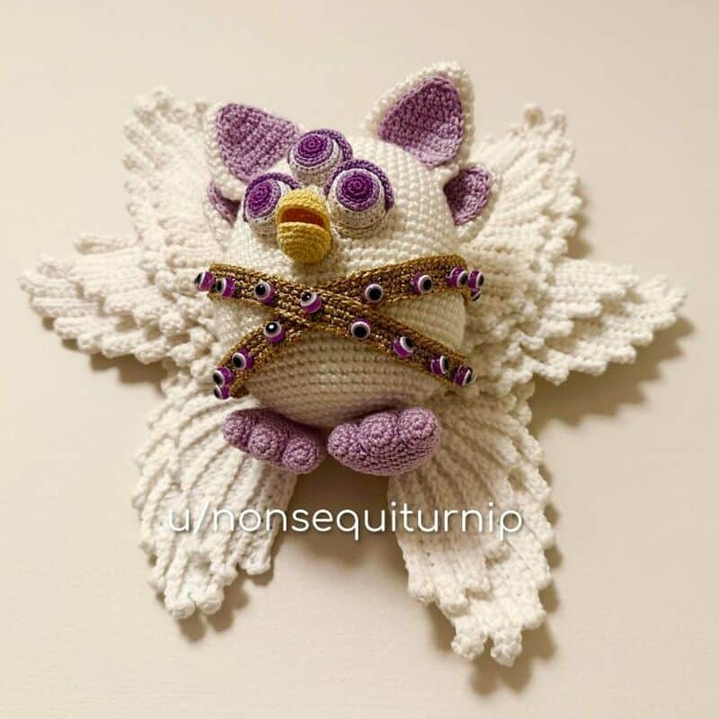 Crochet plush owl with purple accents and wings on a white background.