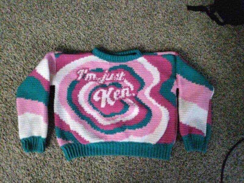 Colorful knitted sweater with pink, white, teal, and purple swirls and 'Kool' text.