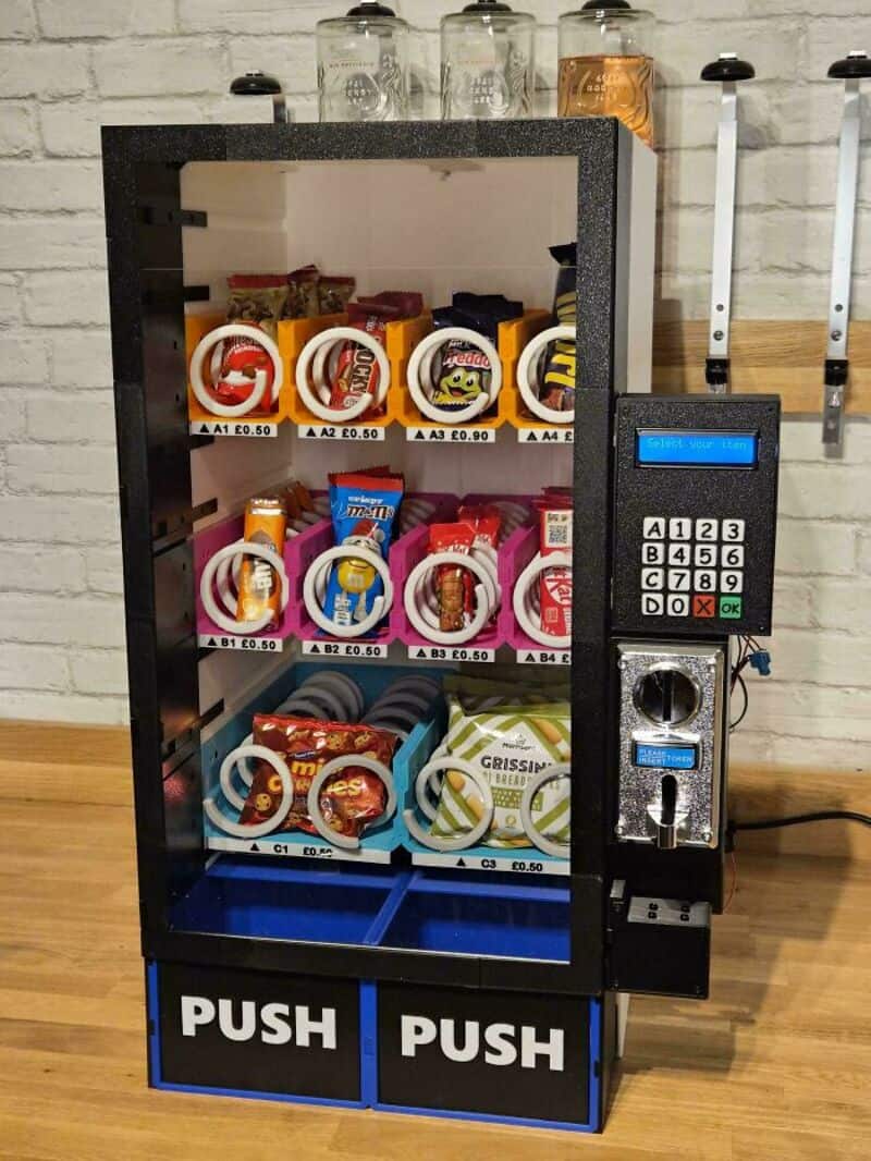 Vending machine with snacks and a payment system, labeled PUSH on the bottom.