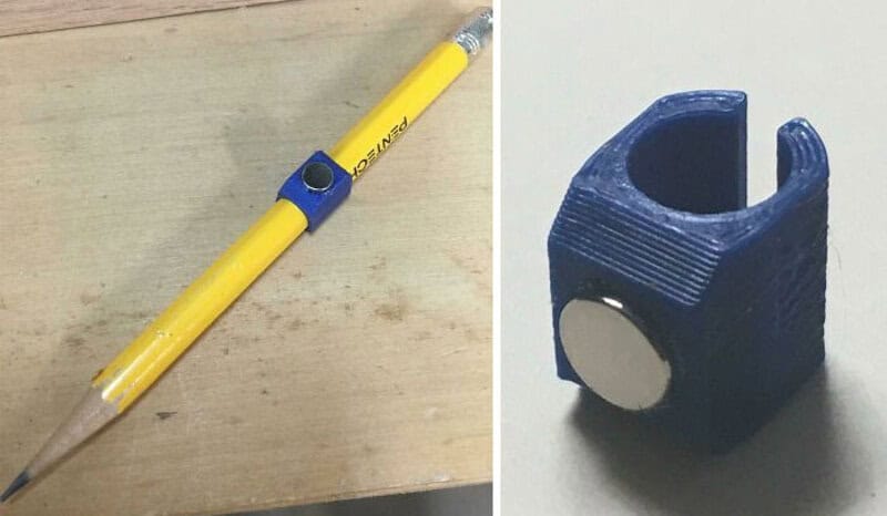 Yellow pen with blue clip and a black tip, placed on a wooden surface.