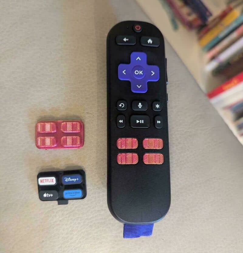 Remote control with pink 3D-printed buttons and streaming service buttons.