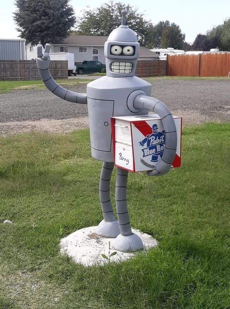 Futuristic robot mailbox holding a Pabst Blue Ribbon box and waving.