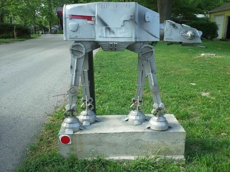 Star Wars AT-AT walker mailbox on a concrete base in a neighborhood.
