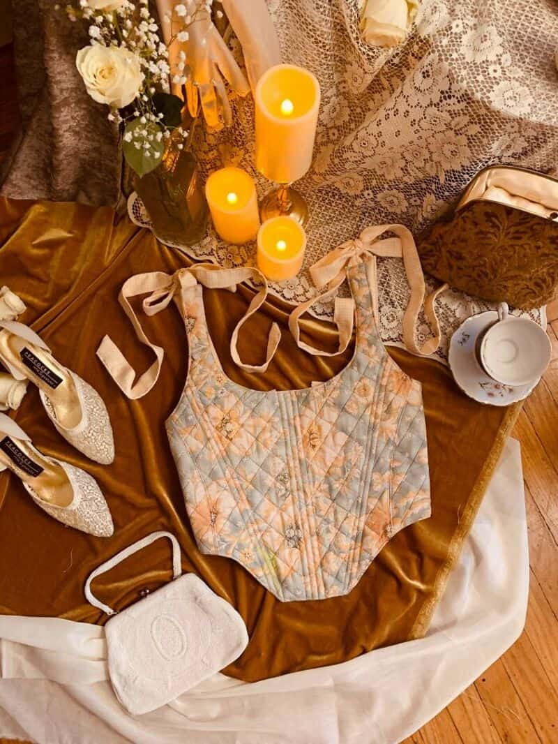 Upcycling craft display with candles, flowers, shoes, and a quilted bag.
