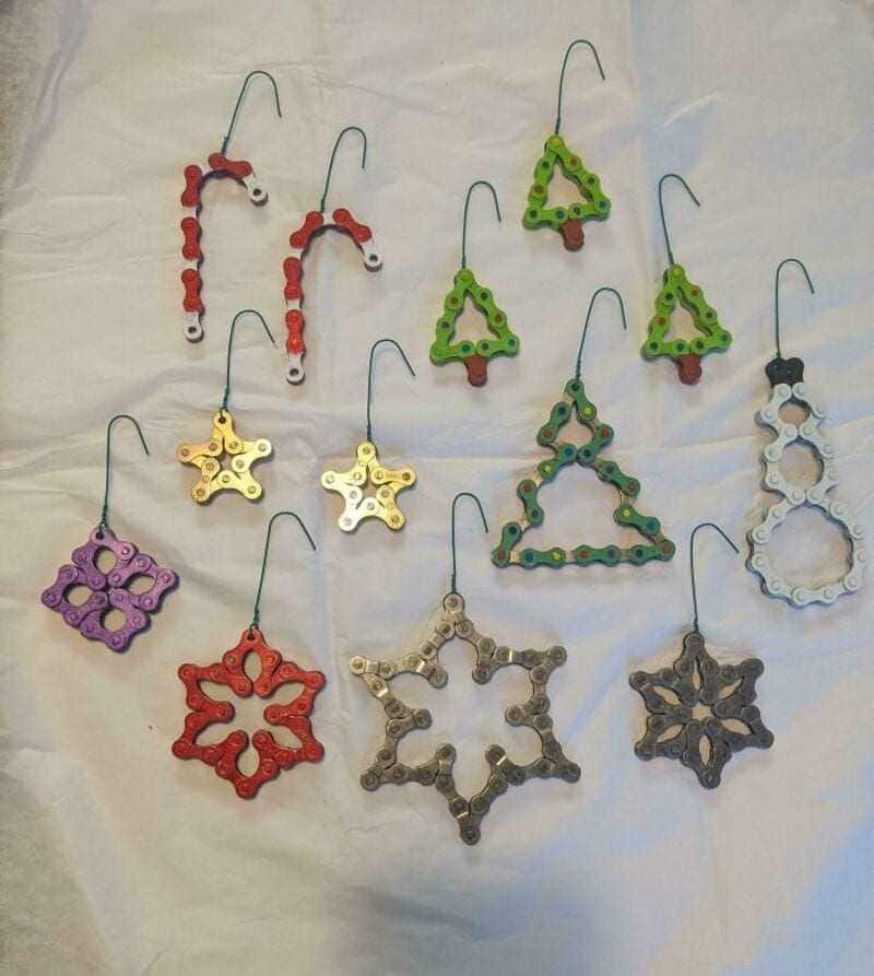 Colorful upcycled jewelry made from bicycle chain links, shaped into stars and trees.
