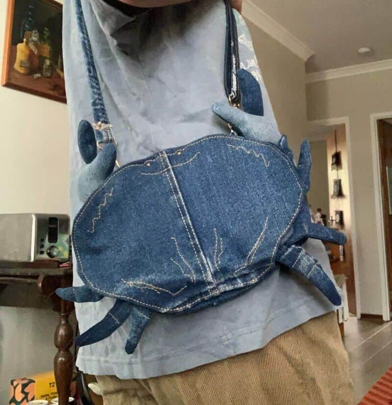 Handmade crab-shaped denim bag with stitched details and straps.
