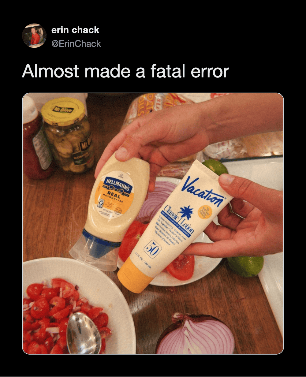 Person holding two sunscreen bottles over a table with food and vegetables.