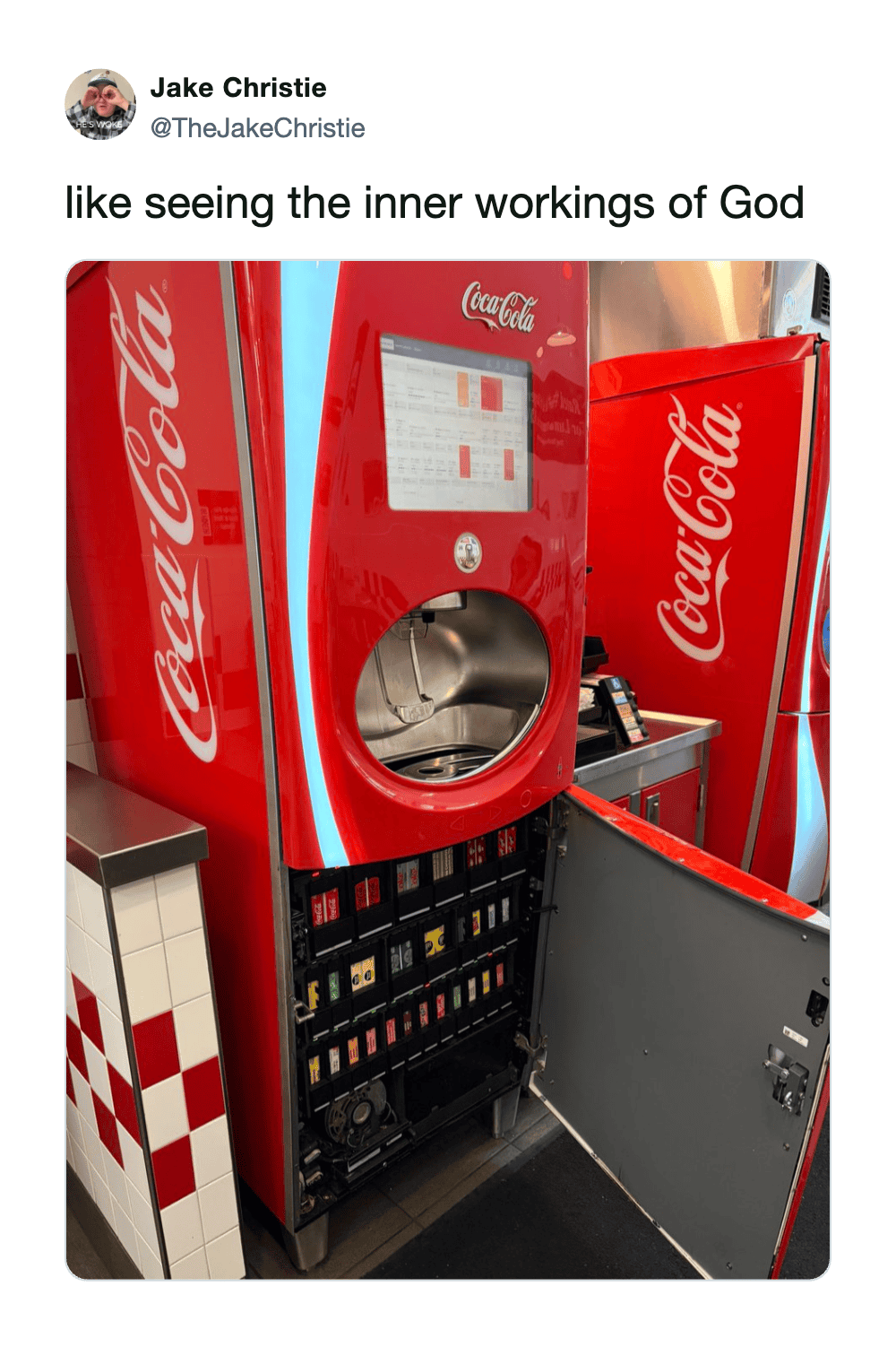 Coca-Cola vending machine with open door showing internal components.