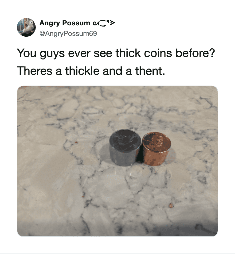 Two coins, one thick and one thin, on a marble surface.