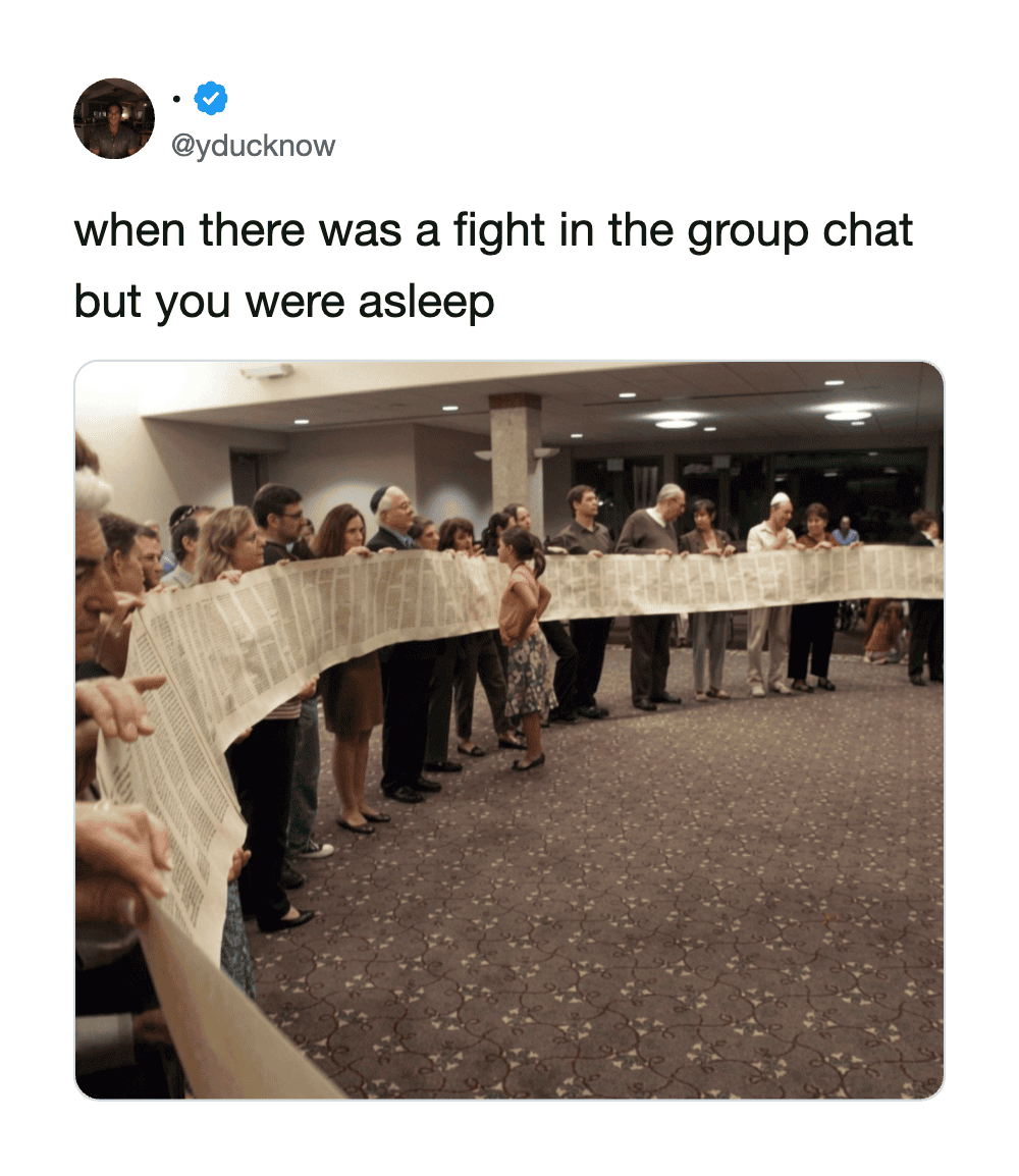 Group of people holding a long newspaper in a room, some looking tired or upset.