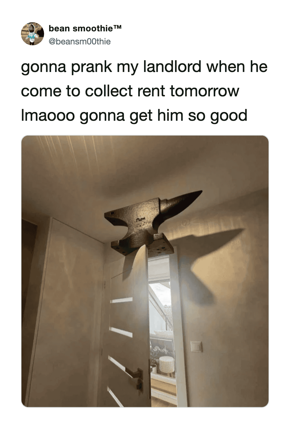 A large, black, cartoonish hammer hanging from the ceiling in a room.