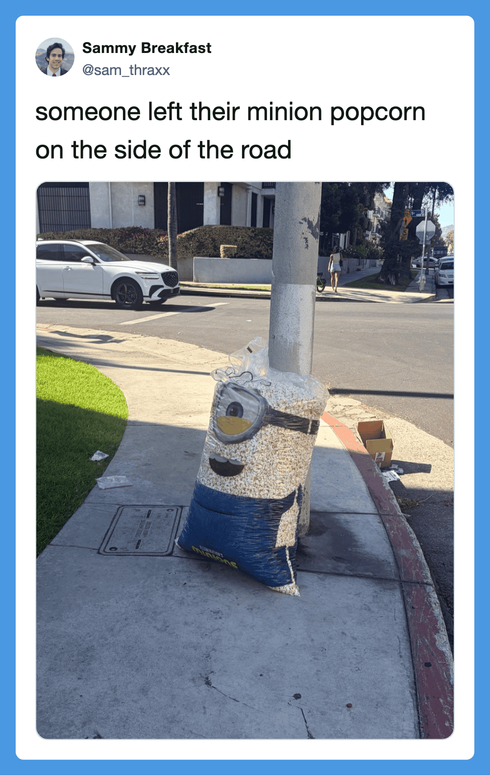 Minion popcorn bag left on the side of the road, with a caption about it.