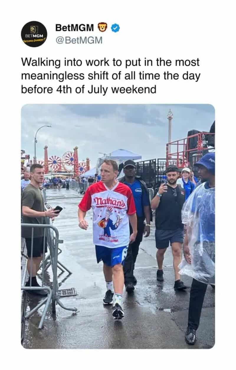 Man walking to work in a rain-soaked amusement park on July 3rd.