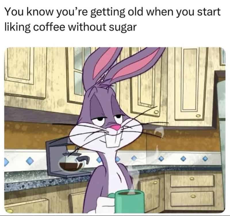 Looney Tunes' Bugs Bunny with a coffee mug, looking tired, in a kitchen.