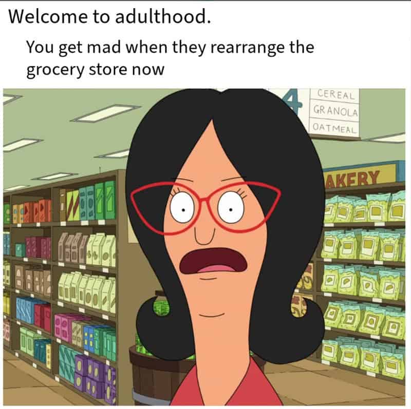 Woman with red glasses and black hair surprised in grocery store.